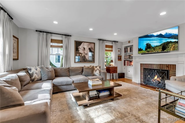 87 Garrison Rd, Amherst, NY 14221 - living room featuring a fireplace, healthy amount of natural light, recessed lighting, built in shelves, and wood finished floors