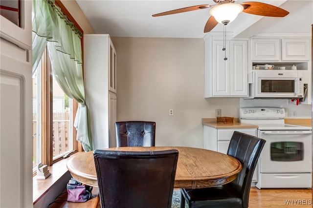 3317 D St, Niagara Falls, NY 14303 - kitchen featuring white appliances, white cabinets, ceiling fan, light countertops, and light wood-style flooring