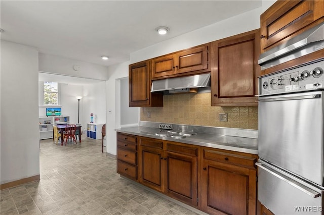 552 Locust St, Lockport-City, NY 14094 - kitchen featuring a warming drawer, stainless steel countertops, under cabinet range hood, stainless steel oven, and backsplash