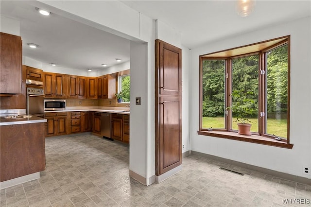 552 Locust St, Lockport-City, NY 14094 - kitchen with appliances with stainless steel finishes, healthy amount of natural light, light countertops, brown cabinets, and recessed lighting