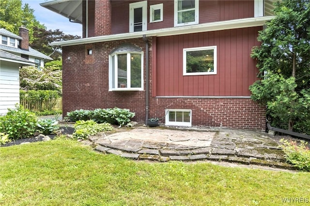552 Locust St, Lockport-City, NY 14094 - view of property exterior featuring a yard, brick siding, and a patio