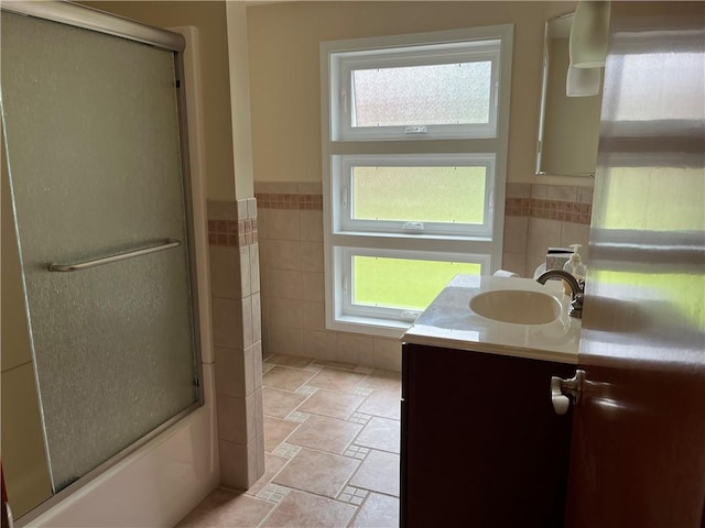 7 Orchard Pl, Bradford-City, PA 16701 - bathroom with vanity, tile walls, plenty of natural light, stone finish floors, and shower / bath combination with glass door