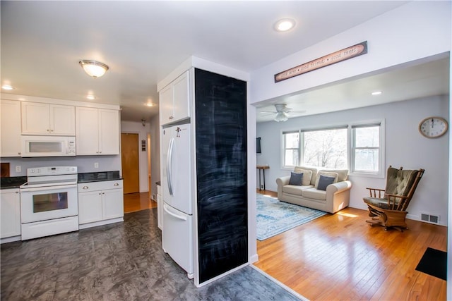 16353 W Lake Rd, Pulteney, NY 14418 - kitchen with white appliances, dark countertops, white cabinets, open floor plan, and recessed lighting