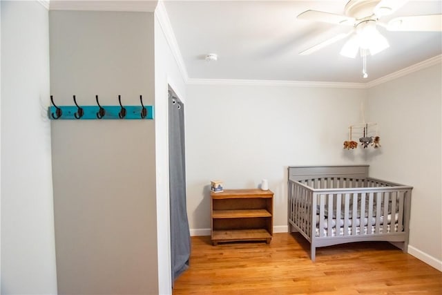 16353 W Lake Rd, Pulteney, NY 14418 - bedroom with ornamental molding, wood finished floors, a crib, and a ceiling fan