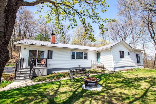 16353 W Lake Rd, Pulteney, NY 14418 - back of property featuring an outdoor fire pit, a chimney, a lawn, and a metal roof