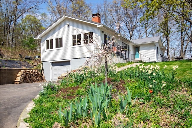 16353 W Lake Rd, Pulteney, NY 14418 - view of front of house featuring asphalt driveway, a chimney, and a garage