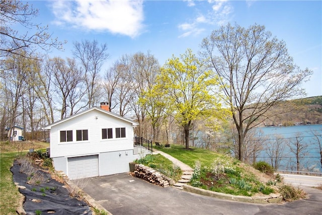 16353 W Lake Rd, Pulteney, NY 14418 - view of home's exterior featuring asphalt driveway, a chimney, a garage, and stairway