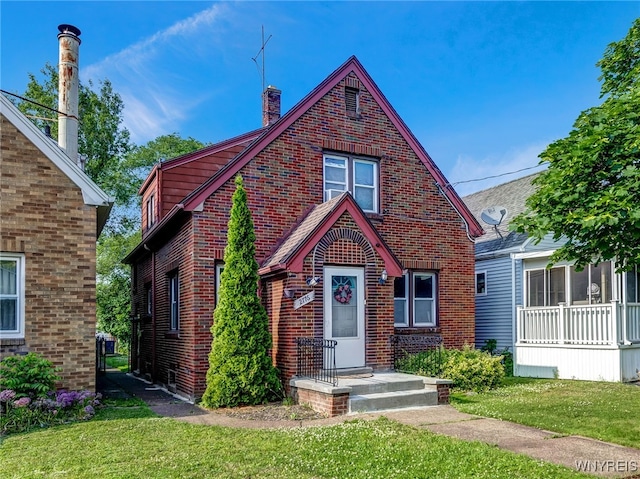 2776 Forest Ave, Niagara Falls, NY 14303 - view of front of home with brick siding, a front yard, and a chimney