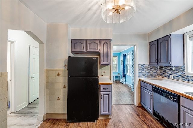 2776 Forest Ave, Niagara Falls, NY 14303 - kitchen with freestanding refrigerator, dishwasher, wood finished floors, light countertops, and tile walls
