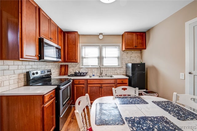 2776 Forest Ave, Niagara Falls, NY 14303 - kitchen with stainless steel appliances, backsplash, light countertops, and light wood-type flooring