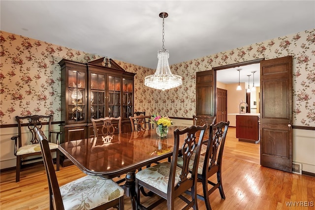 44 Deer Run, Amherst, NY 14221 - dining room with wallpapered walls, wainscoting, a chandelier, and light wood-style floors