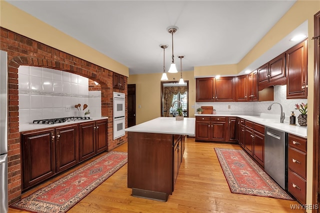 44 Deer Run, Amherst, NY 14221 - kitchen with gas cooktop, stainless steel dishwasher, white double oven, backsplash, and light countertops