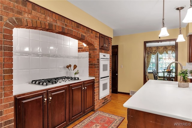 44 Deer Run, Amherst, NY 14221 - kitchen featuring gas cooktop, double oven, light wood-type flooring, light countertops, and tasteful backsplash