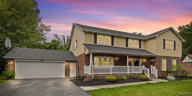 44 Deer Run, Amherst, NY 14221 - traditional-style house with covered porch, driveway, brick siding, and a garage
