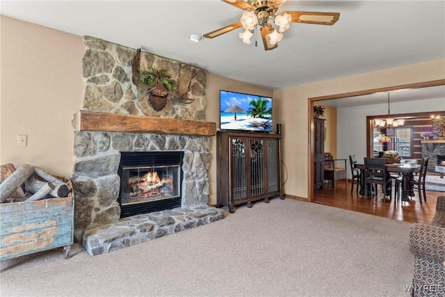 8345 Lapp Rd, Clarence, NY 14051 - carpeted living room featuring a stone fireplace, a chandelier, and ceiling fan