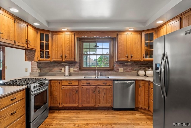 8345 Lapp Rd, Clarence, NY 14051 - kitchen with appliances with stainless steel finishes, brown cabinets, light countertops, light wood finished floors, and recessed lighting