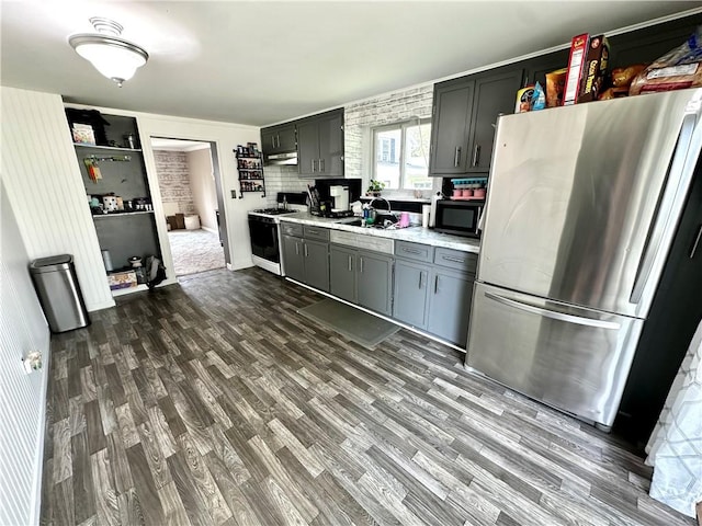 22 Orchard Rd, Greece, NY 14612 - kitchen with freestanding refrigerator, gas range oven, black microwave, light countertops, and dark wood-style floors
