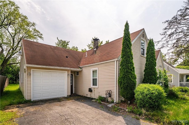 55 Spruce Rd, Amherst, NY 14226 - view of front of home with asphalt driveway, a chimney, and an attached garage