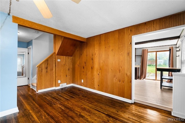 55 Spruce Rd, Amherst, NY 14226 - empty room with wood finished floors, wooden walls, a ceiling fan, and a textured ceiling