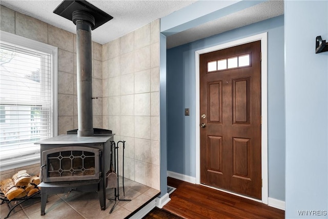 55 Spruce Rd, Amherst, NY 14226 - foyer entrance with a wood stove, dark wood-style flooring, and a textured ceiling