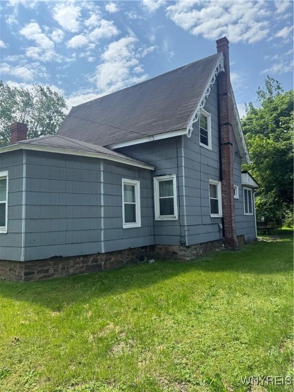 38 N Main St, Royalton, NY 14105 - view of side of home with a chimney and a lawn