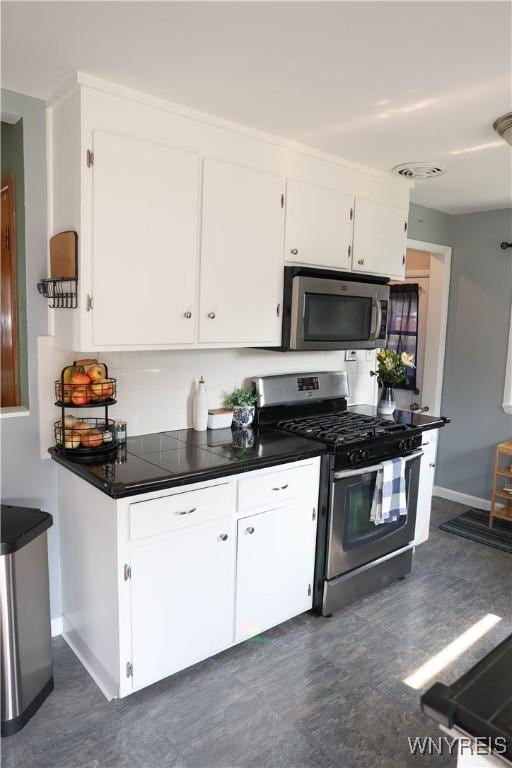 1422 Master St, North Tonawanda, NY 14120 - kitchen featuring stainless steel appliances, white cabinets, and dark countertops