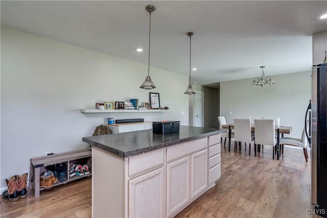 30656 Nys Route 37, Le Ray, NY 13637 - kitchen featuring light wood-style flooring, a chandelier, freestanding refrigerator, dark countertops, and hanging light fixtures