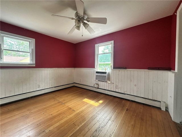 55 Maple St, Canisteo, NY 14823 - empty room with wainscoting, wood-type flooring, cooling unit, a baseboard radiator, and ceiling fan