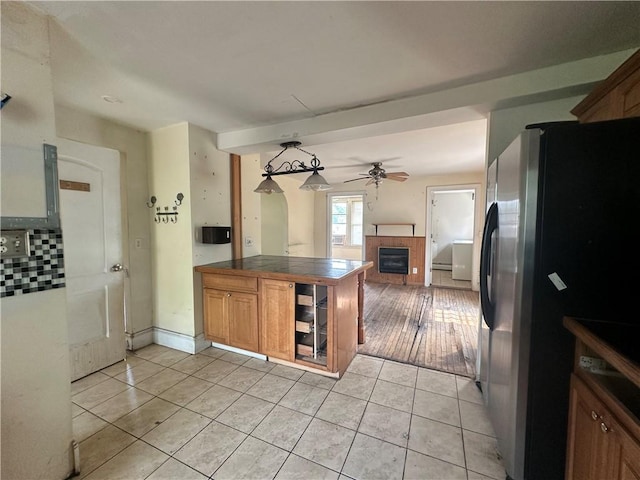 55 Maple St, Canisteo, NY 14823 - kitchen featuring freestanding refrigerator, a tiled fireplace, ceiling fan, light tile patterned floors, and open floor plan