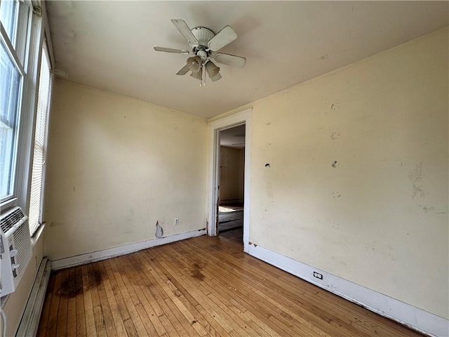 55 Maple St, Canisteo, NY 14823 - empty room with a baseboard radiator, wood-type flooring, and a ceiling fan