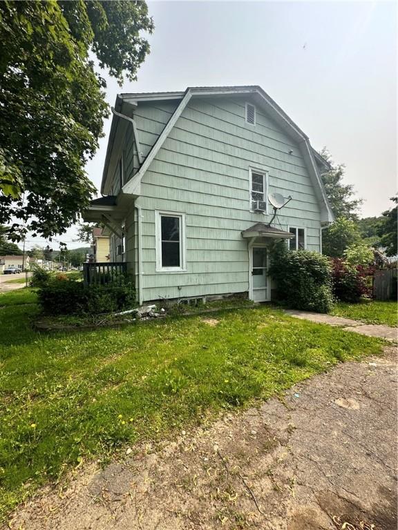 55 Maple St, Canisteo, NY 14823 - view of side of home with a gambrel roof, a lawn, and cooling unit