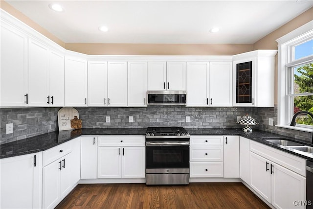 4244 County Line Rd, Skaneateles, NY 13152 - kitchen with stainless steel appliances, white cabinetry, dark stone counters, glass insert cabinets, and recessed lighting
