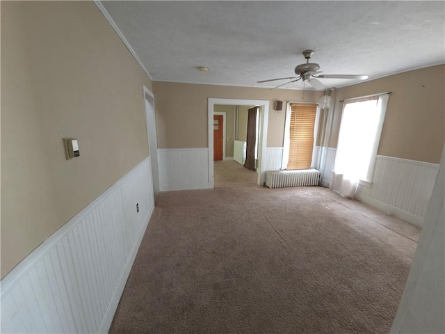 17 Lake St, Mount Morris, NY 14510 - spare room featuring wainscoting, a ceiling fan, radiator heating unit, and carpet