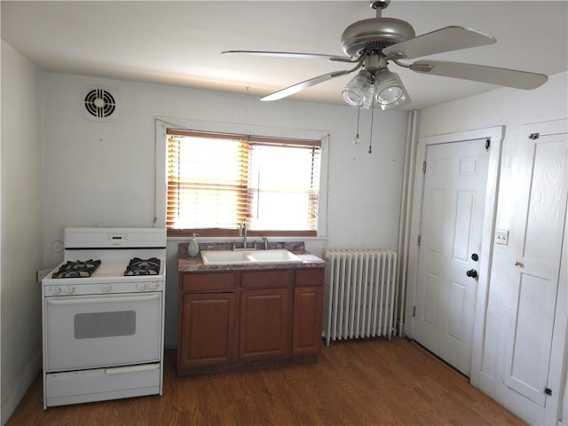 17 Lake St, Mount Morris, NY 14510 - kitchen featuring radiator, white range with gas cooktop, wood finished floors, and ceiling fan