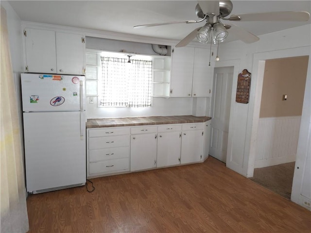 17 Lake St, Mount Morris, NY 14510 - kitchen featuring freestanding refrigerator, light wood-style flooring, ceiling fan, white cabinetry, and wainscoting