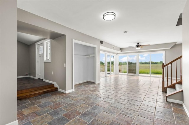4709 Freeman Rd, Royalton, NY 14105 - unfurnished living room with ceiling fan, stone tile flooring, and stairway