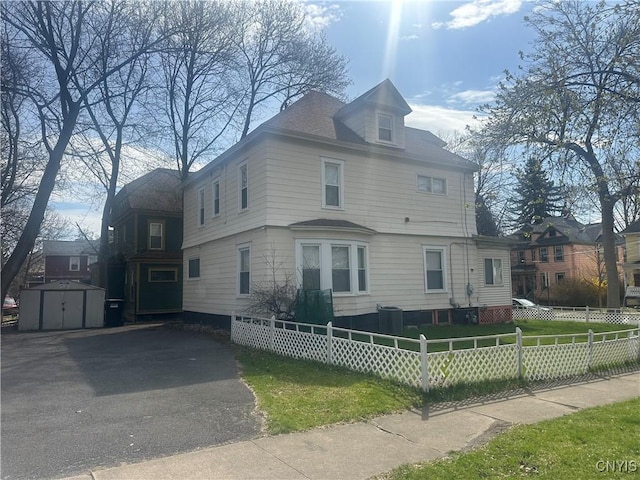 101 Avondale Pl, Syracuse, NY 13210 - view of front of property featuring a storage unit, a fenced front yard, and asphalt driveway