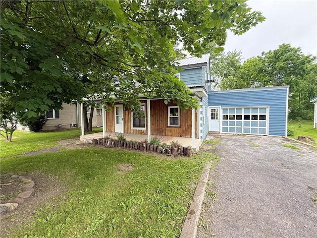 73 E River St, Fayette, NY 13165 - obstructed view of property with a garage, covered porch, driveway, and a front lawn