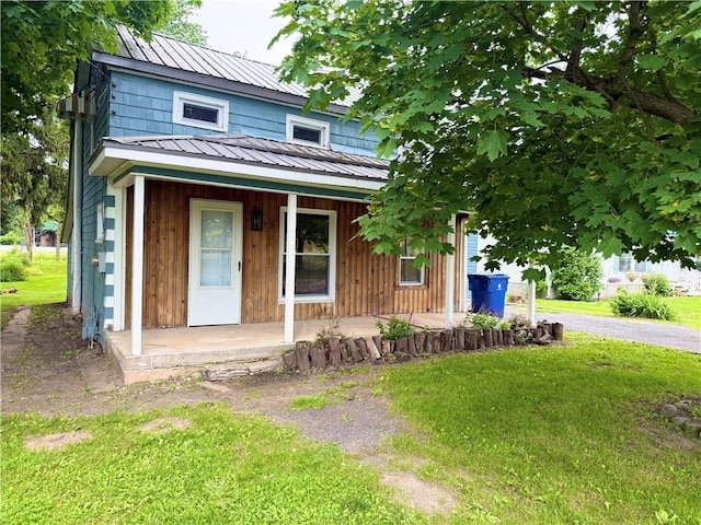 73 E River St, Fayette, NY 13165 - view of front facade featuring covered porch, a front lawn, and a metal roof