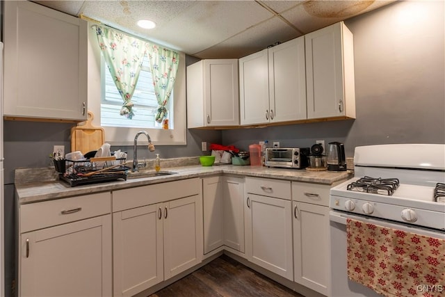 221.5 Lakeview Ave, Syracuse, NY 13204 - kitchen featuring white gas range, light countertops, white cabinets, dark wood finished floors, and a drop ceiling