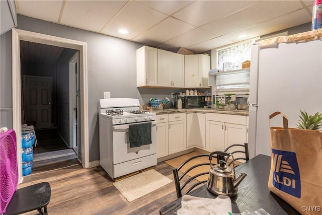 221.5 Lakeview Ave, Syracuse, NY 13204 - kitchen featuring white appliances, a drop ceiling, wood finished floors, white cabinets, and recessed lighting