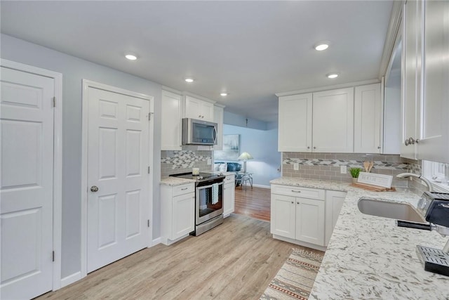 21 Wethersfield Rd, Chili, NY 14624 - kitchen featuring stainless steel appliances, light wood finished floors, white cabinetry, backsplash, and recessed lighting