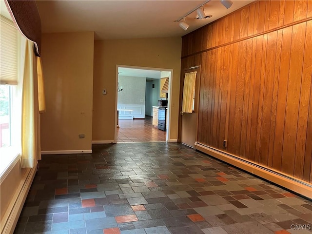 462 Hacadam Rd, Frankfort, NY 13456 - empty room featuring baseboard heating, rail lighting, a baseboard radiator, and wooden walls