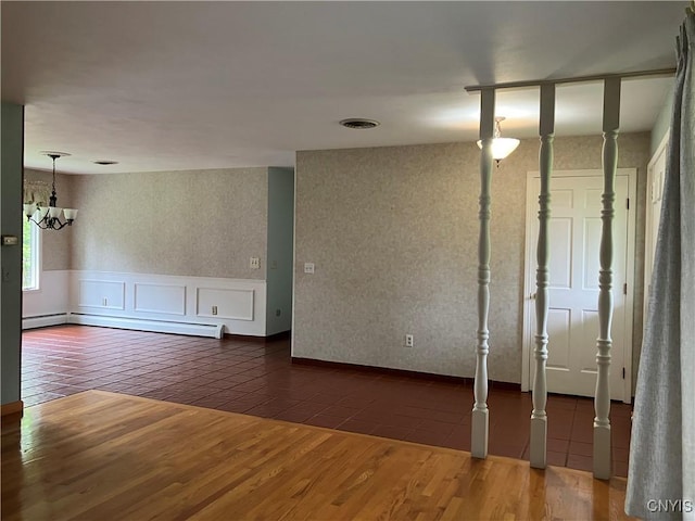 462 Hacadam Rd, Frankfort, NY 13456 - empty room with a baseboard heating unit, a chandelier, wood finished floors, wainscoting, and wallpapered walls