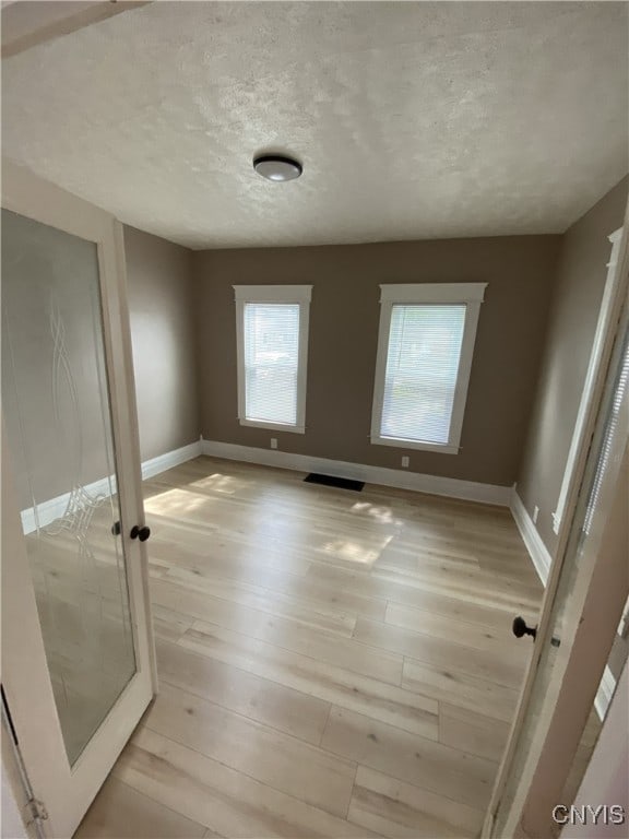 409 W 1st St S, Fulton, NY 13069 - unfurnished bedroom featuring light wood finished floors and a textured ceiling