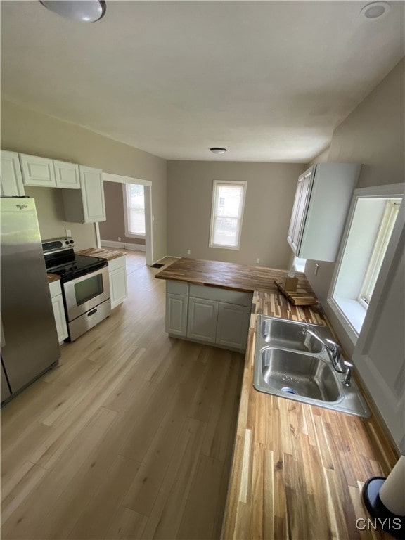 409 W 1st St S, Fulton, NY 13069 - kitchen featuring stainless steel appliances, wood counters, white cabinetry, and light wood-style floors