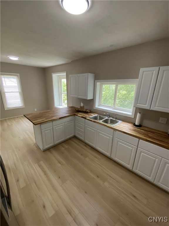 409 W 1st St S, Fulton, NY 13069 - kitchen with butcher block counters, light wood-style flooring, white cabinetry, and healthy amount of natural light