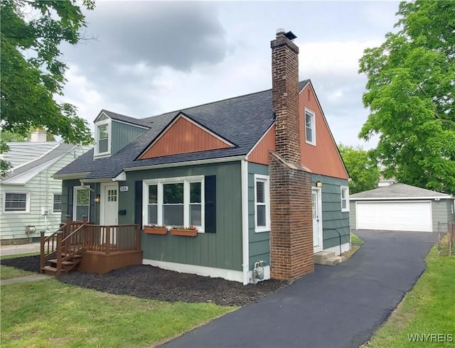 126 Onondaga Ave, West Seneca, NY 14220 - view of front of house featuring an outdoor structure, a garage, a shingled roof, a chimney, and a front yard