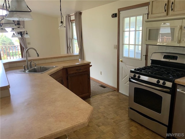 926 Bluff Rd, Carlton, NY 14571 - kitchen featuring stainless steel range with gas cooktop, white microwave, light countertops, decorative light fixtures, and dishwashing machine