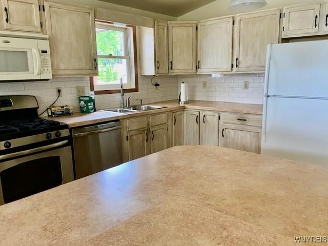 926 Bluff Rd, Carlton, NY 14571 - kitchen with stainless steel appliances, light countertops, and decorative backsplash